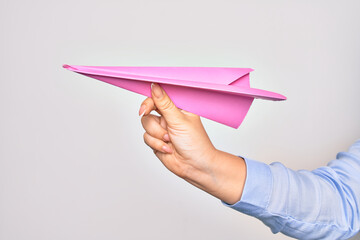 Hand of caucasian young woman holding paper airplane over isolated white background