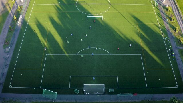 Aerial view of a soccer aka football team training on a green football field.