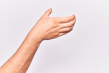 Close up of hand of young caucasian man over isolated background holding invisible object, empty hand doing clipping and grabbing gesture