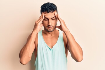 Fototapeta premium Young hispanic man wearing casual clothes with hand on head, headache because stress. suffering migraine.