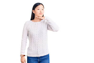 Young beautiful chinese woman wearing casual sweater cutting throat with hand as knife, threaten aggression with furious violence