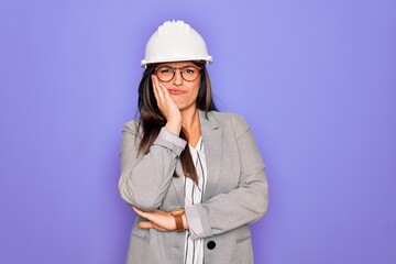 Professional woman engineer wearing industrial safety helmet over pruple background thinking looking tired and bored with depression problems with crossed arms.