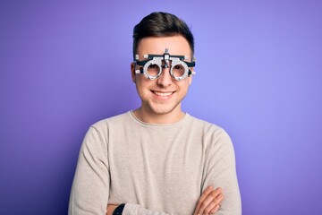 Young handsome caucasian man wearing optometrical glasses over purple background happy face smiling with crossed arms looking at the camera. Positive person.