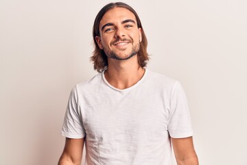 Young handsome man wearing casual clothes looking positive and happy standing and smiling with a confident smile showing teeth