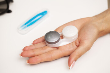 Woman holding a container with contact lenses for vision correction