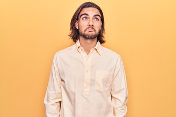 Young handsome man wearing business clothes smiling looking to the side and staring away thinking.