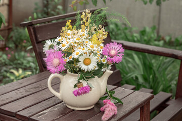 Wildflowers in an old little village teapot. Toned