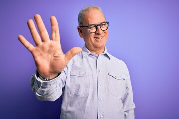 Naklejka premium Middle age handsome hoary man wearing striped shirt and glasses over purple background showing and pointing up with fingers number five while smiling confident and happy.