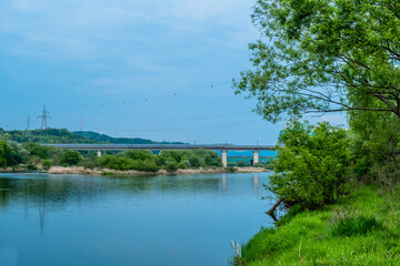 Obraz premium Calm river with train on bridge