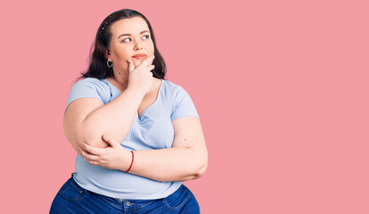 Young plus size woman wearing casual clothes with hand on chin thinking about question, pensive expression. smiling with thoughtful face. doubt concept.