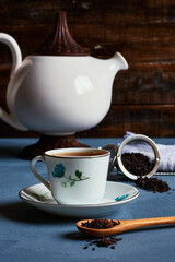 tea cup with teapot and infuser strands with accessories