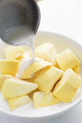 Thai dessert, sliced durian fruit in a bowl eating with coconut milk