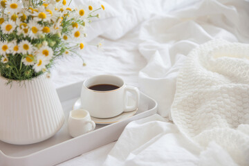 Cozy breakfast in bed, cup of coffee and milk on the grey fabric, space for text. Alarm clock for seven in the morning.