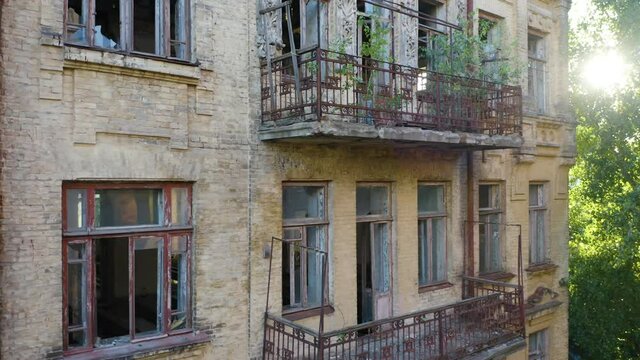Abandoned old commercial apartment building in the Art Nouveau style (Modern Style) with a broken windows and balconies. Deserted early 20th century house. Aerial side view