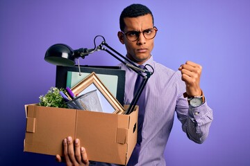 Handsome african american man fired holding box with work objects over purple background annoyed and frustrated shouting with anger, crazy and yelling with raised hand, anger concept