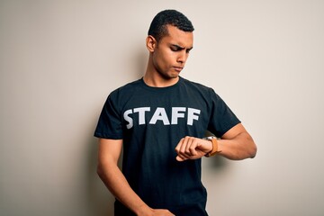 Young handsome african american worker man wearing staff uniform over white background Checking the time on wrist watch, relaxed and confident
