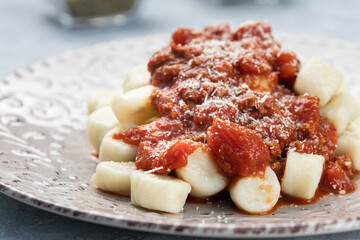 Gnocchi dish, served with tomato sauce and Parmesan cheese.