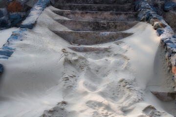 This unique photo shows a stone staircase on the beach which is almost completely covered with sand that was blown by the wind.