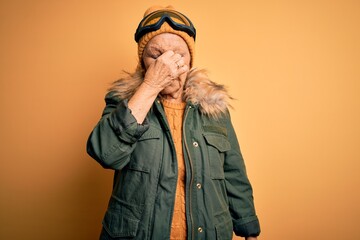 Senior beautiful grey-haired skier woman wearing snow sportswear and ski goggles tired rubbing nose and eyes feeling fatigue and headache. Stress and frustration concept.