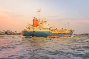 Fototapeta premium Massive container ship for import export and business logistic. Big cargo ship is leaving from Bangkok Port Authority of Thailand or Klong Toey port along Chao Phraya river in Bangkok,Thailand.