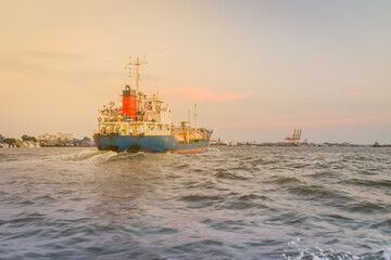Massive container ship for import export and business logistic. Big cargo ship is leaving from Bangkok Port Authority of Thailand or Klong Toey port along Chao Phraya river in Bangkok,Thailand.
