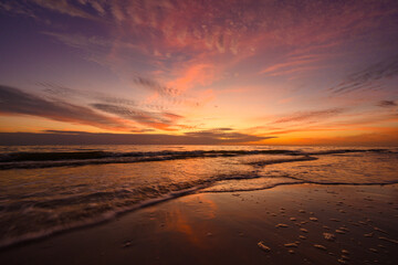 Fototapeta na wymiar Sunset Reflects as Waves Recede