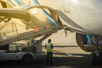 Airplane staffs of Bangkok Airways (a regional airline based in Bangkok) is uploading baggage before taking off at Suvarnabhumi Airport.