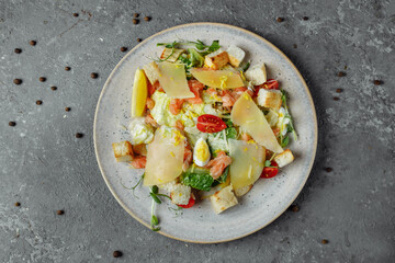Caesar salad with salmon and fresh vegetables. Top view. Free space for your text