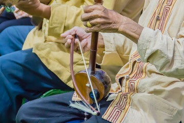 Closeup the musician during play the Salor (Lanna Traditional Fiddle), a Thai musical instrument such as stringed instruments. Make a sound by using the bow rub to the strung.