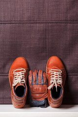 Motorcycling Concepts. Set of Protective Motorcyclist Leather Footwear And tanned Leather Gloves Placed Together Against Fabric Background.