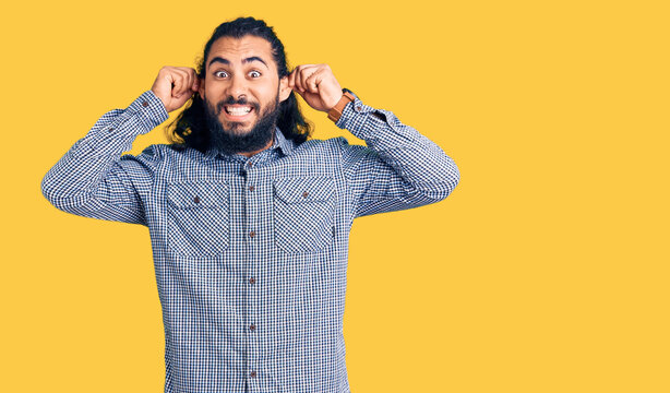 Young arab man wearing casual clothes smiling pulling ears with fingers, funny gesture. audition problem