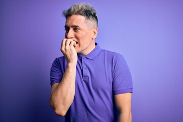 Young handsome modern man wearing casual purple t-shirt over isolated background looking stressed and nervous with hands on mouth biting nails. Anxiety problem.