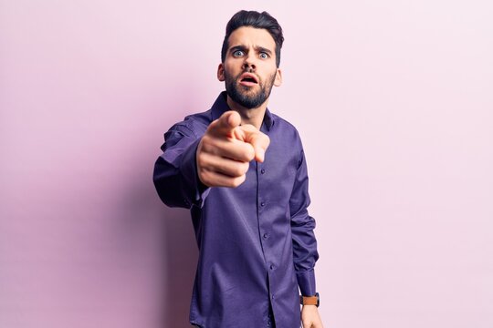 Young handsome man with beard wearing casual shirt pointing displeased and frustrated to the camera, angry and furious with you