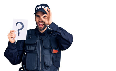Young handsome man with beard wearing police uniform holding question mark smiling happy doing ok sign with hand on eye looking through fingers