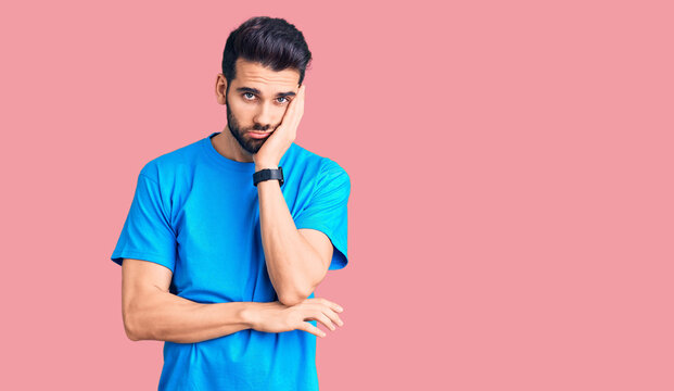 Young handsome man with beard wearing casual t-shirt thinking looking tired and bored with depression problems with crossed arms.