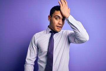 Young brazilian businessman wearing elegant tie standing over isolated purple background surprised with hand on head for mistake, remember error. Forgot, bad memory concept.