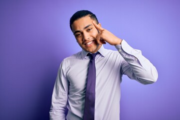 Young brazilian businessman wearing elegant tie standing over isolated purple background Smiling pointing to head with one finger, great idea or thought, good memory