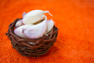 Cloves of raw Garlic in wooden small vintage nest as bowl. Spices for cooking