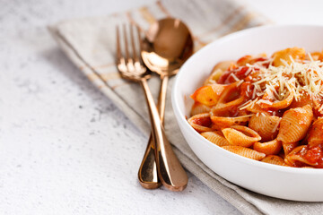 Pasta conchiglie with tomato sauce and parmesan cheese
