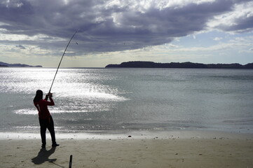 fishing, fisherman, beach, sea, water, rod, ocean, fish, sunset, sport, sand, silhouette, surf, waves, pole, coast, leisure, angling, sky, casting, vacation, sun, angler, hobby, recreation