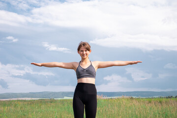 Girl doing sports workout and exercises outdoor in nature.