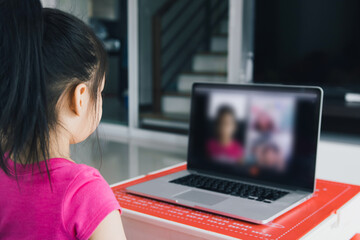 Little asian girl attending to online e-learning platform class from home while school has been closed during coronavirus outbreak.