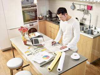 high angle view of an young asian designer working in kitchen at home