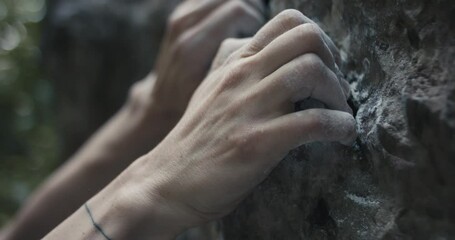 Female climber woman athlete holds grip with fingers chalk on hand rock climb ascends outdoors lifestyle sport in nature unrecognizable macro close up slow motion - Powered by Adobe