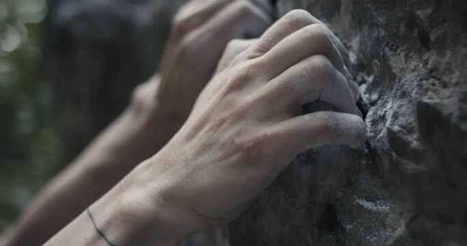 Female climber woman athlete holds grip with fingers chalk on hand rock climb ascends outdoors lifestyle sport in nature unrecognizable macro close up slow motion