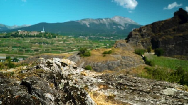 Beautiful vista overlooking Swiss Alps village of Sion with rocks in foreground