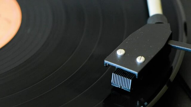 Rock music vinyl record disc spinning on a retro-style vinyl disc player. Closeup of a vinyl record disc.