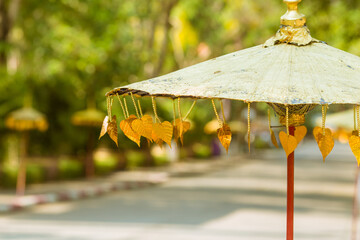 An umbrella that is decorated with golden leaves.