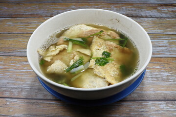 Hot soup of fried chicken eggs (omelette egg) with chopped spring onion and seasoning with pepper on the bowl. Famous traditional local soup menu in Asia street food. Comfortable food. 