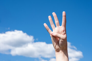 Gesture closeup of a woman's hand showing four fingers, sign language symbol number four